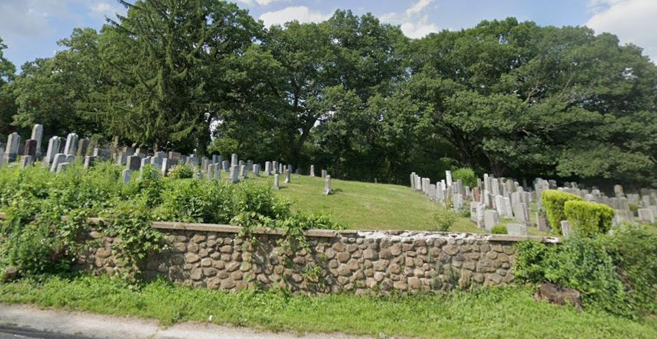 Farband Waterbury Cemetery grounds with stone wall and gravestones