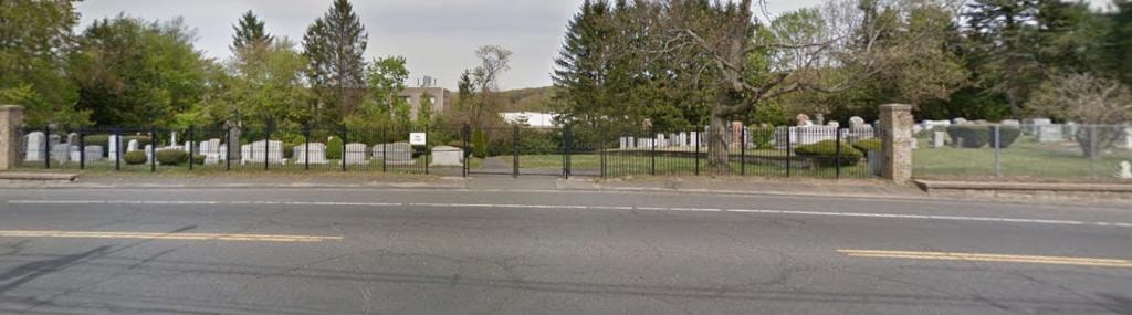 Star Lodge Cemetery entrance with iron fence and gate along Stillson Road, gravestones and trees visible beyond